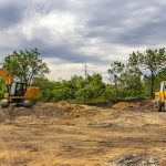 Parked excavators at the construction site, after work. Panoramic view
